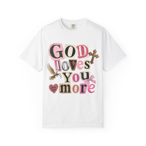 A white short-sleeve crewneck t-shirt featuring a colorful graphic on the front that reads 'GOD LOVES YOU more' in a patchwork-style font with a dove, heart, and cross illustrations.