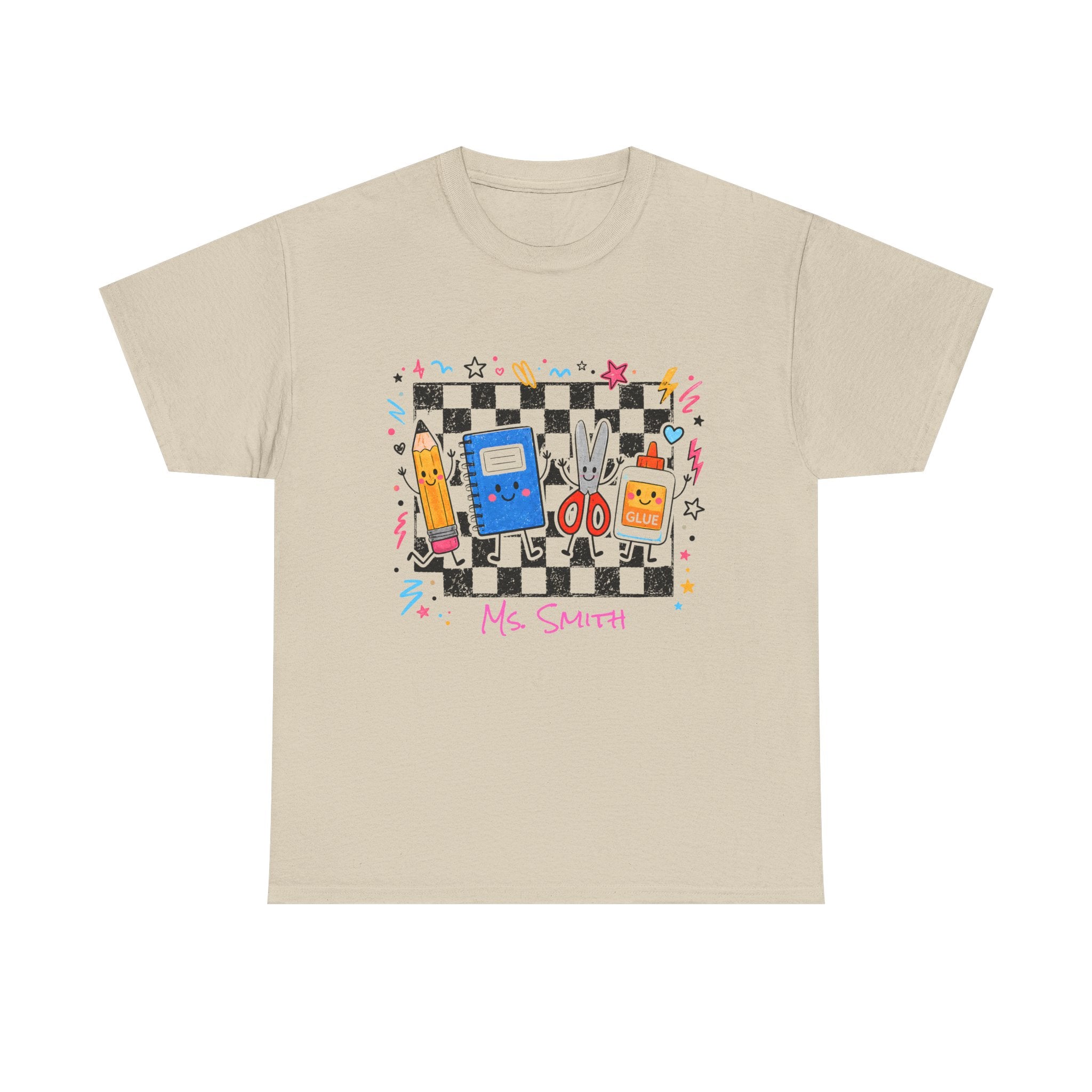 A Sand colored short-sleeve crewneck t-shirt featuring a colorful retro-themed graphic on the chest. The graphic depicts a black and white checkerboard background with various school supplies, a blue notebook, a yellow pencil, and the text 'Ms.Smith’