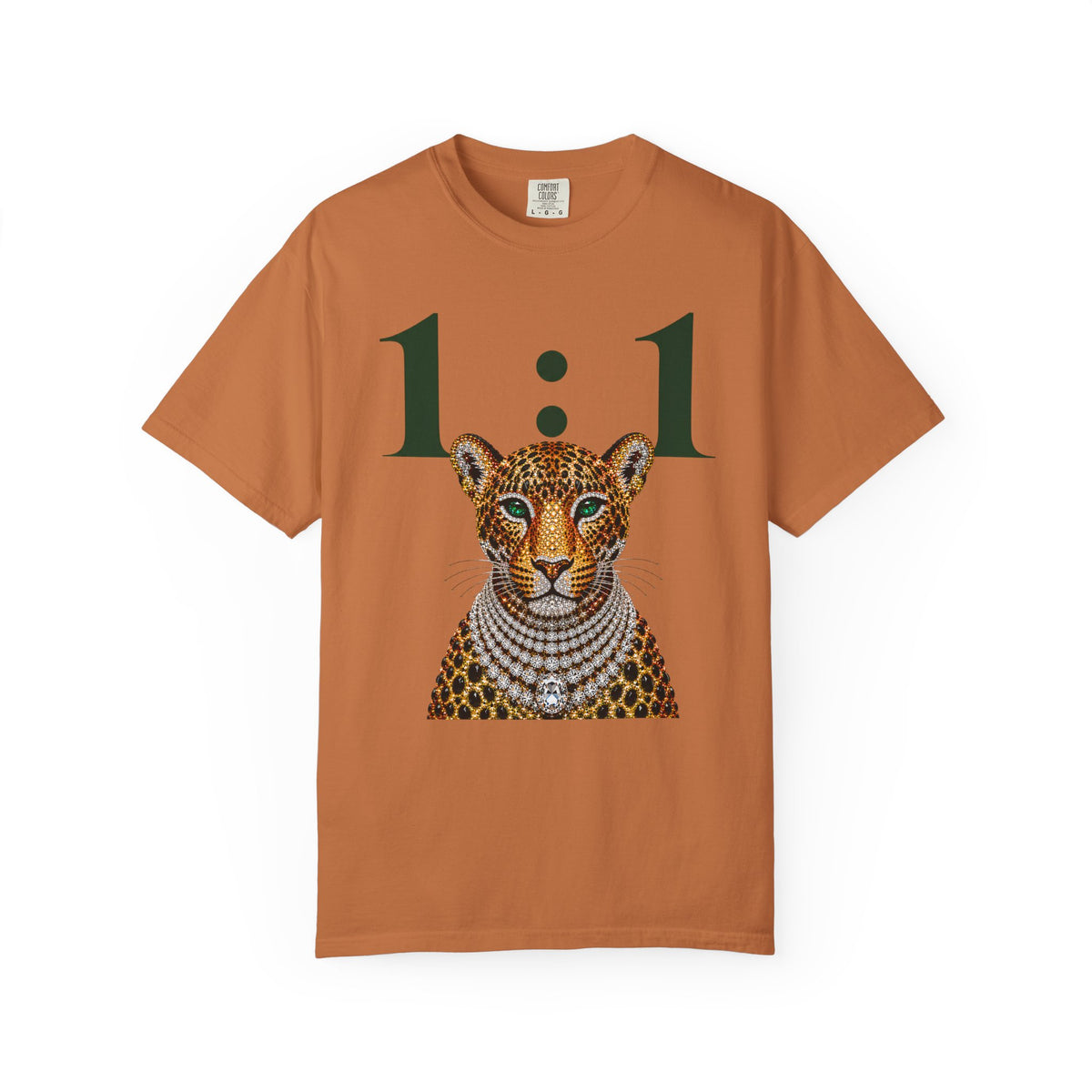A rust-orange short-sleeve t-shirt featuring a graphic print of a leopard adorned with diamond-like jewelry and the text '1:1' in dark green, displayed on a clean white background.