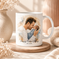 White mug with a printed design of a man holding a baby and 'Happy Father's Day' text, placed on a wooden coaster.
